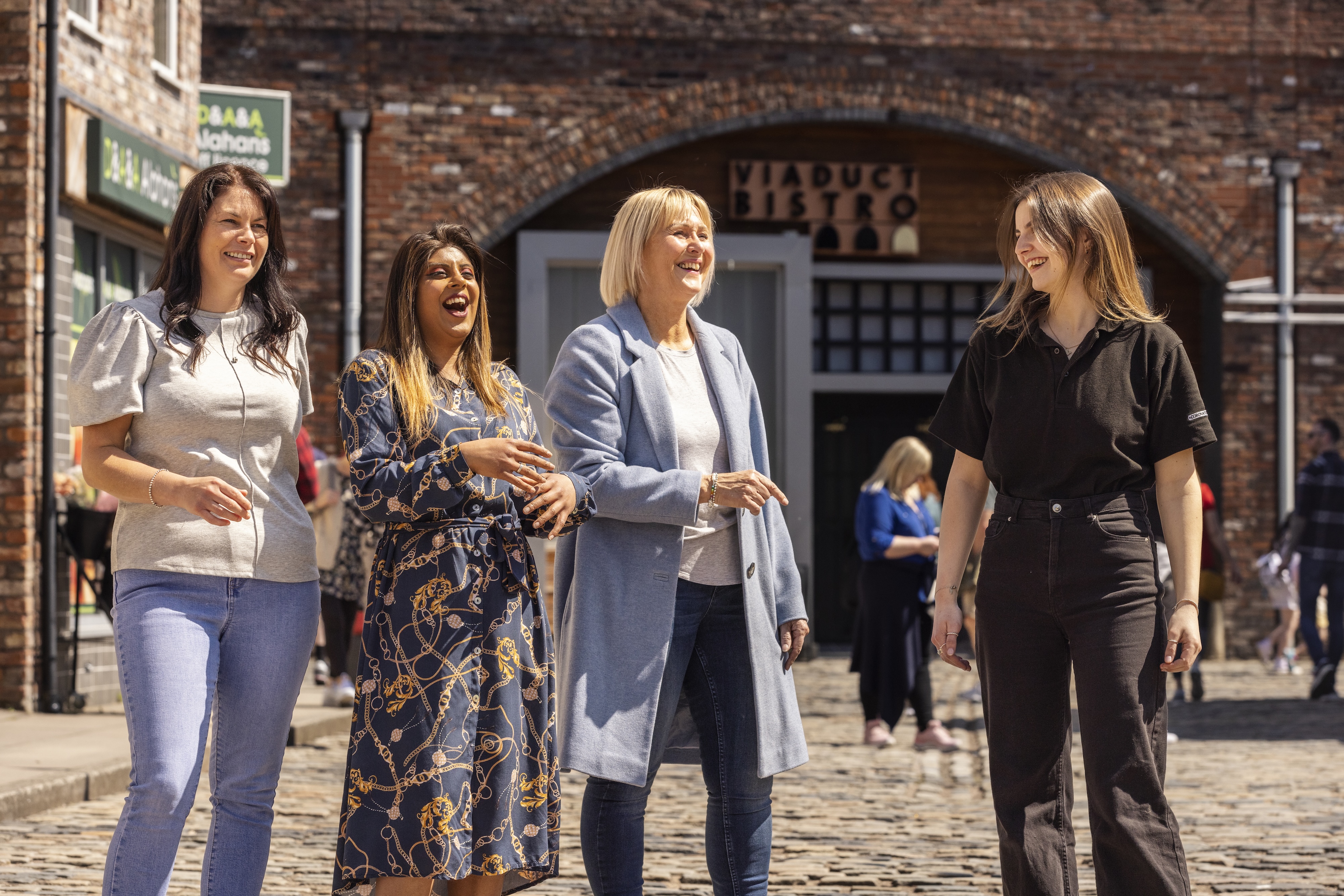 An expert guide leading enthusiastic guests around the Coronation Street Experience
